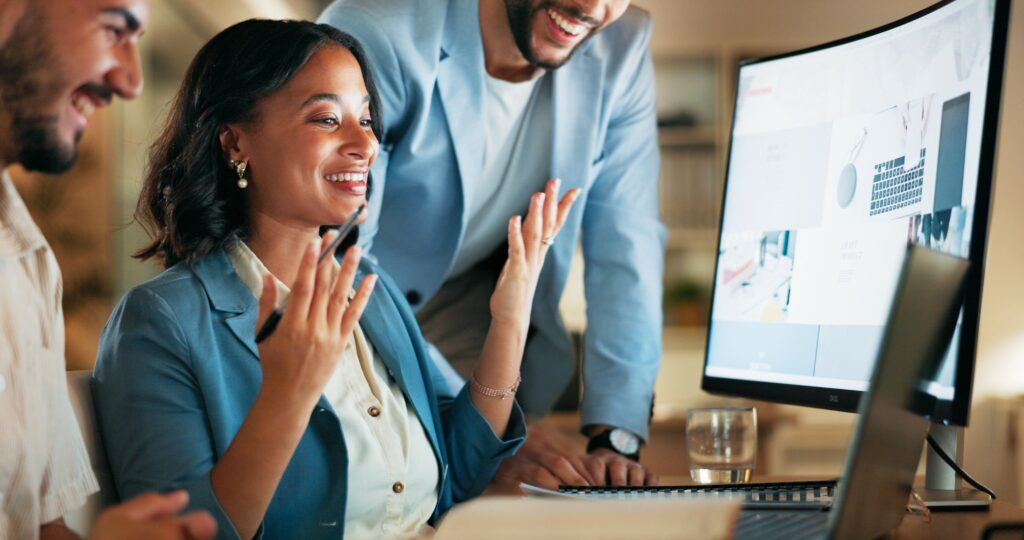 A team of professionals collaborates around a computer, reviewing real-time data on a large monitor—illustrating how TPAs use real-time health data to improve employer outcomes.