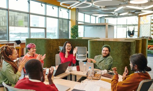 A diverse group of employees clapping and celebrating together in a modern office, representing a successful culture initiative launch, team engagement, and shared momentum.